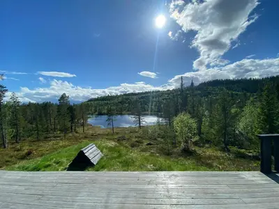 a view of a lake with the sun in the sky at Cabin By Trillemarka Nature Reserve in Eiddal