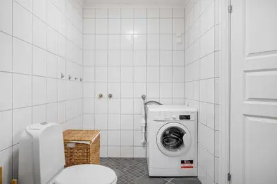 a bathroom with a washing machine and a toilet at Fjellvangvegen 11 by Vacation Trysil in Trysil