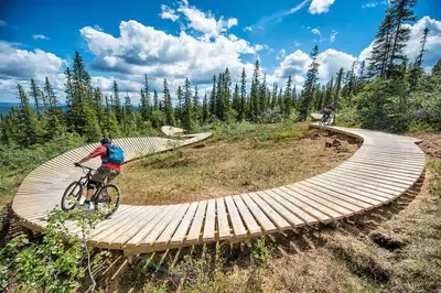 a man riding a bike on a wooden boardwalk at Fjellvangvegen 11 by Vacation Trysil in Trysil
