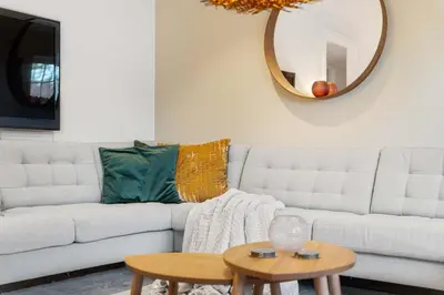 a living room with a white couch and a circular mirror at Fjellvangvegen 11 by Vacation Trysil in Trysil