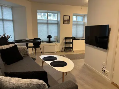 a living room with a couch and a table at Modern Apt - Steps from Grieghallen and Trainstation in Bergen