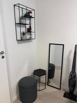 a room with a mirror and a chair and a stool at Modern Apt - Steps from Grieghallen and Trainstation in Bergen