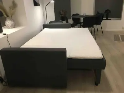 a bed in a room with a table and chairs at Modern Apt - Steps from Grieghallen and Trainstation in Bergen