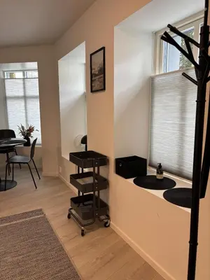 a room with a hair salon with a table and a window at Modern Apt - Steps from Grieghallen and Trainstation in Bergen