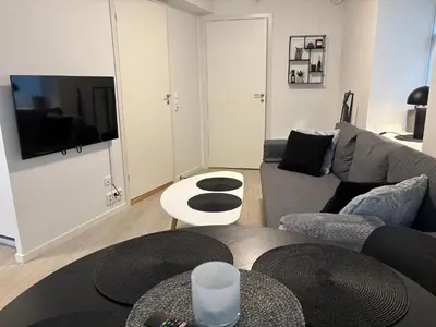 a living room with a couch and a table at Modern Apt - Steps from Grieghallen and Trainstation in Bergen