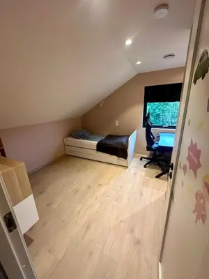 a small room with a bed and a desk in it at Spacious, central 3 BR house with parking in Bergen