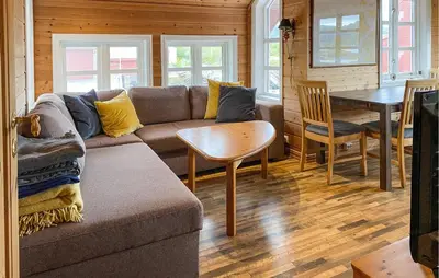 a living room with a couch and a table at Gorgeous Home In Leinøy With House Sea View in Fosnavåg
