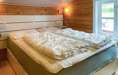 a large bed in a room with a window at Gorgeous Home In Leinøy With House Sea View in Fosnavåg