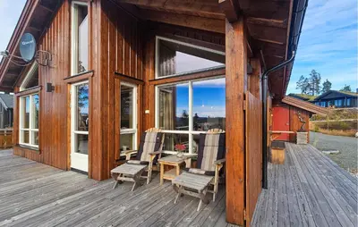 a cabin with two chairs and a table on a deck at 3 Bedroom Lovely Home In Flå in Flå