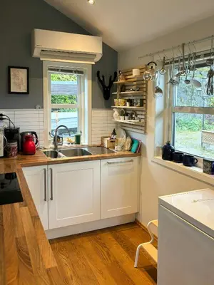 a kitchen with white cabinets and a sink and a window at Modern Cabin With Panoramic Views In Aukland in Jelsa