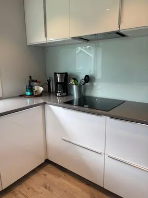 a kitchen with white cabinets and a sink at Koselig rom i studentfelleskap