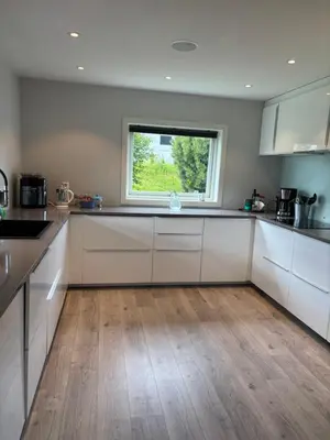 a kitchen with white cabinets and a window at Koselig rom i studentfelleskap