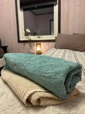 a green blanket sitting on top of a bed at Koselig rom i studentfelleskap