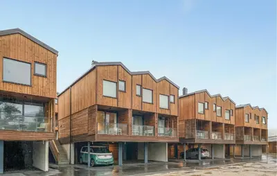 a row of wooden buildings in a parking lot at Beautiful Home In Bjorli in Bjorli
