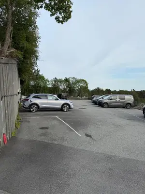 a row of parked cars in a parking lot at Askvik Marina Lägenhet i småbåtshamn med havsutsikt