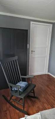 a rocking chair sitting in a room with a door at Comfortable apartment near the city center and nature