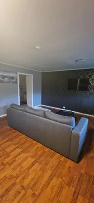 a couch in a living room with a wooden floor at Comfortable apartment near the city center and nature