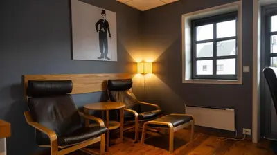 a waiting room with chairs and a table at Vestnes Fjordhotell in Vestnes