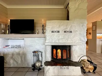 a stone fireplace in a room with a tv at Spacious cabin in Hemsedal with sauna, near slopes in Hemsedal