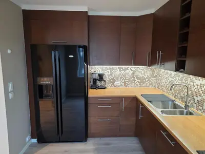 a kitchen with a black refrigerator and a sink at Kristiansund Luxury Apartment in Kristiansund
