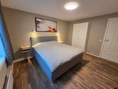 a bedroom with a bed and a painting on the wall at Kristiansund Luxury Apartment in Kristiansund
