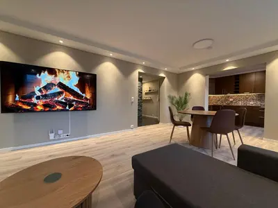 a living room with a large tv on the wall at Kristiansund Luxury Apartment in Kristiansund