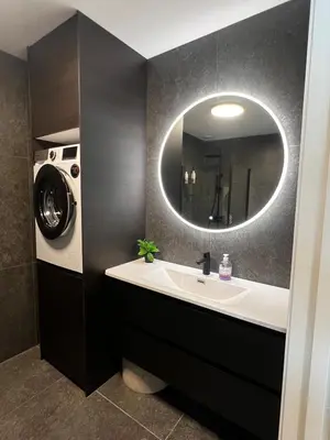 a bathroom with a sink and a washing machine at Newly refurbished apartment in the city center in Verdal