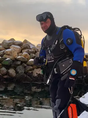 a man standing next to a pile of rocks at Strand huset in Hitra