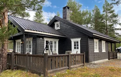 a small black house with a wooden fence at Gorgeous Home In Bjorli With Wifi in Bjorli