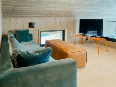 a living room with a couch and a table at Modern Family Cabin By The Ski Trail In Tuddal in Tuddal