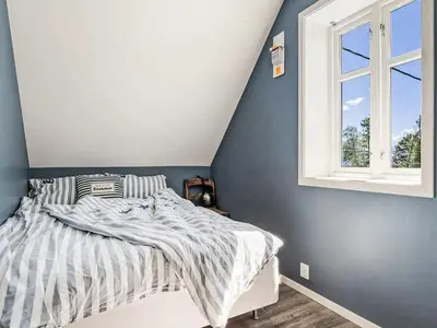 a bedroom with a bed and a window at Holiday Home Holmen by Interhome in Strandebarm