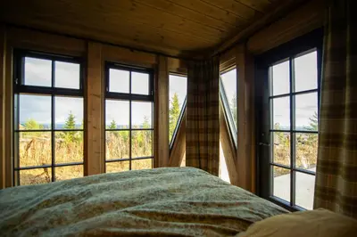 a bedroom with four windows and a bed in front thereof at Handcrafted Log Cabin At Golsfjellet in Gol