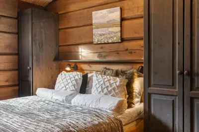 a bedroom with a bed and a wooden wall at Trysilfjell 615 by Vacation Trysil in Trysil