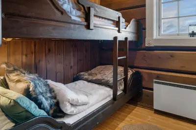 two bunk beds in a room with wooden walls at Trysilfjell 615 by Vacation Trysil in Trysil
