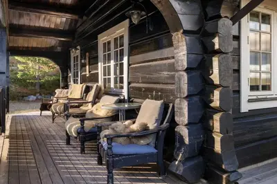 a row of chairs and tables on the porch of a building at Trysilfjell 615 by Vacation Trysil in Trysil