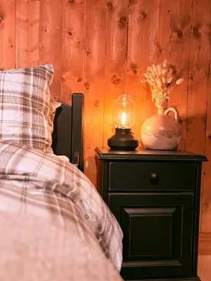 a bedroom with a bed and a table with a lamp at Nikolaisens Nordic Panorama hideaway in Stranda