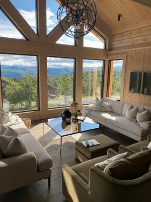 a living room with couches and a large window at Exclusive cottage on Geilo in Hol