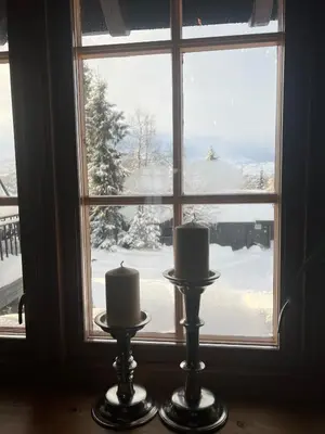two candles in front of a window with snow at Cabin in Kvamskogen in Kvam