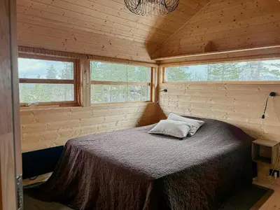 a bedroom with a bed in a wooden cabin at Ål Cabin With Views Of Marshland And Mountains in Flå