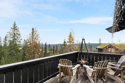 a balcony with two chairs and a table with a view at Trysilfjell hytteområde 922 by Vacation Trysil in Trysil