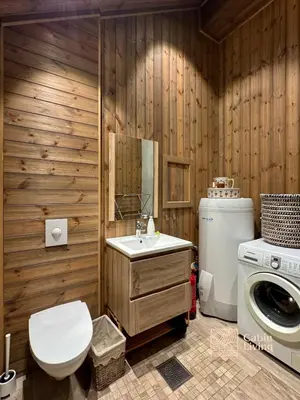 a bathroom with a toilet sink and a washing machine at Modern cabin with panoramic view, sauna and fire pit in Espedalen