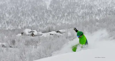 a man riding a snowboard down a snow covered slope at Skarslia Apartment in Skarsgård