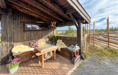 a house with a bench and a table on a deck at Amazing Home In Sjusjøen With Sauna in Sjusjøen