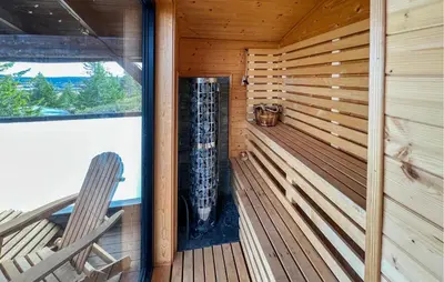 a sauna with a bench and a chair in a cabin at Amazing Home In Sjusjøen With Sauna in Sjusjøen