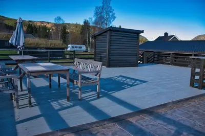 a patio with a table and chairs and an umbrella at Ringen Camping in Vestre Gausdal