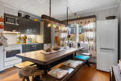 a kitchen with a wooden table and a refrigerator at Fageråsen 209 by Vacation Trysil in Trysil