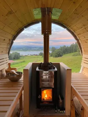 a wood stove in a room with a window at Cosy farmhouse with spa as add on service in Gjøvik