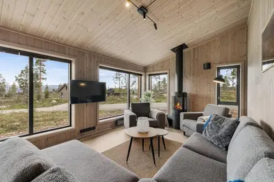 a living room with a couch and a tv at Sentralt plassert hytte, alt i gangavstand in Flå