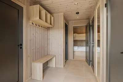 a hallway with wooden walls and a bench in a room at Sentralt plassert hytte, alt i gangavstand in Flå