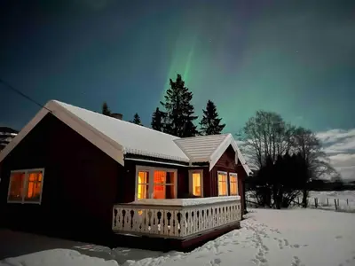 a house with the northern lights in the sky at Det vesle huset på Lysåker in Nord-Fron
